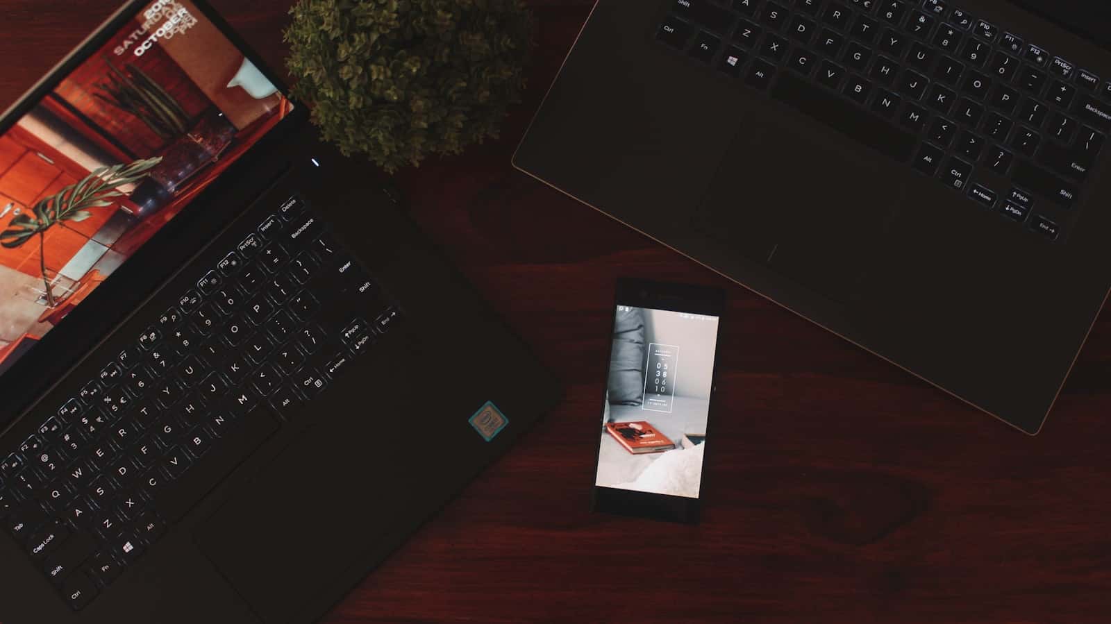 A phone and two laptops on a desk during a review