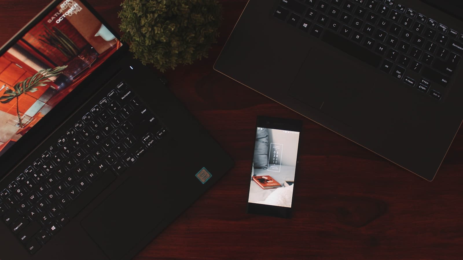 A phone and two laptops on a desk during a review